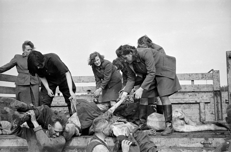 Женщины из охраны СС концлагеря Берген-Бельзен разгружают трупы узников.jpeg
