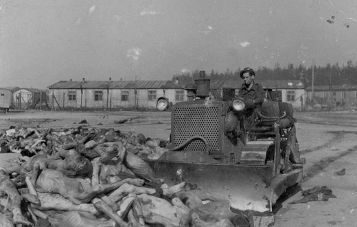 Британский солдат на бульдозере собирает трупы узников концлагеря Берген-Бельзен